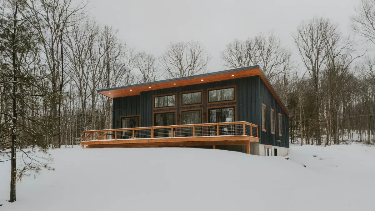 Maison contemporaine en bois entourée de neige au cœur de l’hiver