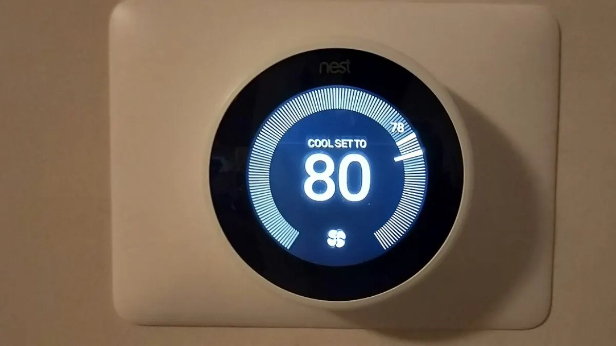 Thermostat d’ambiance mural affichant la température de consigne dans un salon